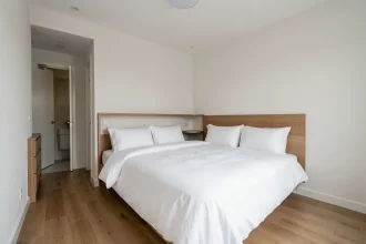 Suite parentale de 15m2 avec lit double, rangements intégrés et parquet chêne dans un style scandinave épuré